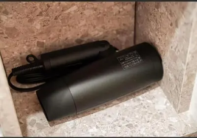 a black blow dryer sitting on a counter at Oshiage SAIEI Hotel 402 in Tokyo