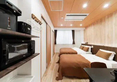 two beds in a small room with a tv at Oshiage SAIEI Hotel 402 in Tokyo