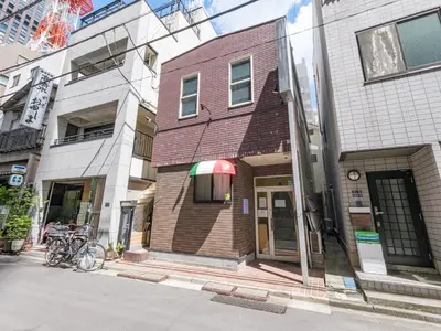 a building on a city street with bikes parked outside at Tokyo Tower Hostel Shiba Park - \u6771\u4eac\u30bf\u30ef\u30fc\u30db\u30b9\u30c6\u30eb\u829d\u516c\u5712 - \u7fbd\u7530\u7a7a\u6e2f\u307e\u3067\u30a2\u30af\u30bb\u30b9\u629c\u7fa4 \u6771\u4eac\u30bf\u30ef\u30fc\u5f92\u6b6915\u5206 \u7121\u6599Wi-Fi in Tokyo