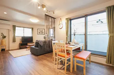 a living room with a table and a dining room at Miraisya Hatsudai in Tokyo