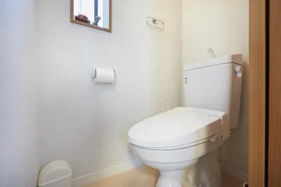 a bathroom with a toilet and a picture on the wall at Miraisya Hatsudai in Tokyo