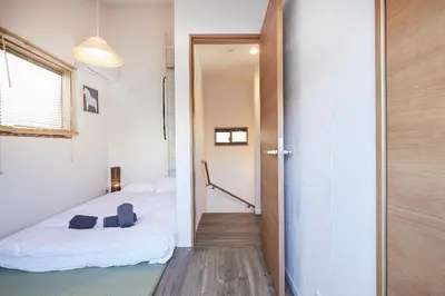 a room with a bed and a door leading to a bedroom at Miraisya Hatsudai in Tokyo