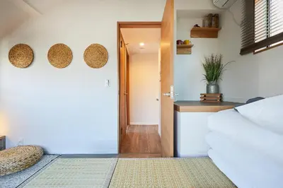 a room with a bed and a hallway with a door at Miraisya Hatsudai in Tokyo