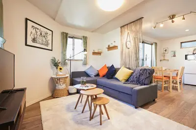 a living room with a couch and a table at Miraisya Hatsudai in Tokyo