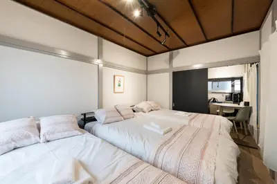 a bedroom with two beds and a desk at AkebonoHouse201 in Tokyo