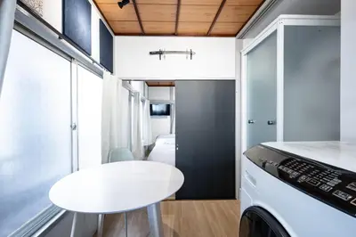 a small kitchen with a white table and a stool at AkebonoHouse201 in Tokyo