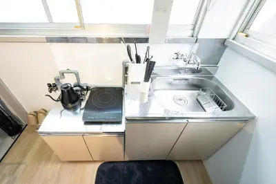 a kitchen with a sink and a laptop on a counter at AkebonoHouse201 in Tokyo