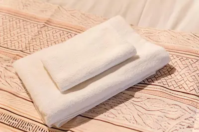 a white towel sitting on top of a bed at AkebonoHouse201 in Tokyo