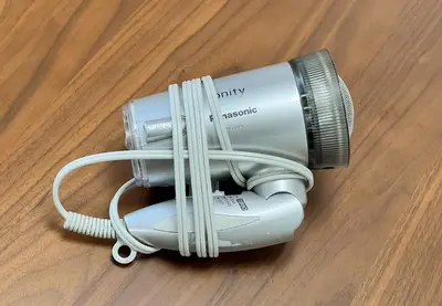 a hair dryer sitting on top of a wooden floor at \u3071\u3093\u3060\u30db\u30b9\u30c6\u30eb\u5ca9\u8c37 in Tokyo