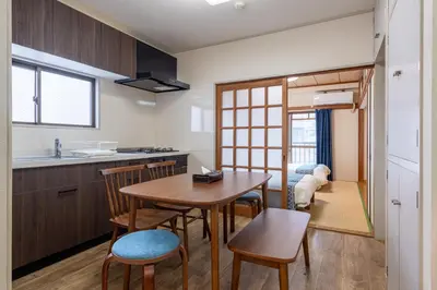 a kitchen and dining room with a table and chairs at \u3071\u3093\u3060\u30db\u30b9\u30c6\u30eb\u5ca9\u8c37 in Tokyo