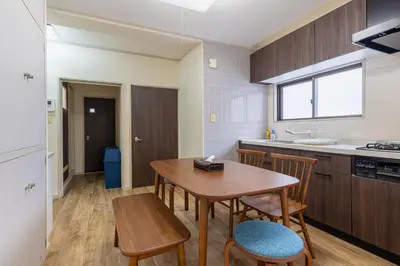 a kitchen and dining room with a wooden table and chairs at \u3071\u3093\u3060\u30db\u30b9\u30c6\u30eb\u5ca9\u8c37 in Tokyo