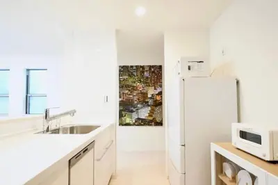 a white kitchen with a sink and a refrigerator at miraisya shiinamachi in Tokyo