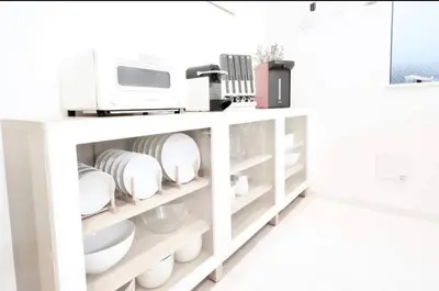 a white shelf with dishes and a printer on it at miraisya shiinamachi in Tokyo