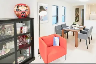 a living room with a red chair and a table at miraisya shiinamachi in Tokyo