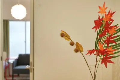 a vase with red and orange flowers in a room at miraisya kyojima in Tokyo
