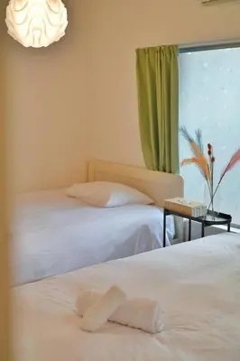 two beds in a room with a window at miraisya kyojima in Tokyo