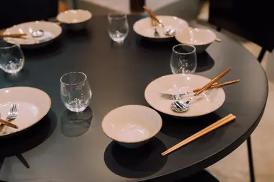 a black table with plates and chopsticks and glasses at Ivy Harajuku in Tokyo