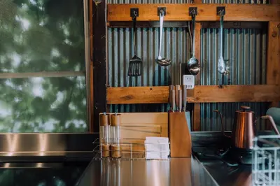 a kitchen with a counter with utensils on the wall at Ivy Harajuku in Tokyo