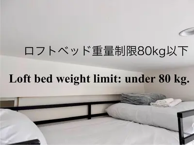 a bedroom with a bed with a sign on the wall at Monthly \u516d\u672c\u6728\u9ebb\u5e03\u30b9\u30ab\u30a4\u30c6\u30e9\u30b9 in Tokyo