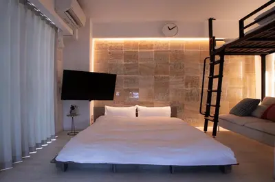 a bedroom with a bed and a tv and a couch at Monthly \u516d\u672c\u6728\u9ebb\u5e03\u30b9\u30ab\u30a4\u30c6\u30e9\u30b9 in Tokyo