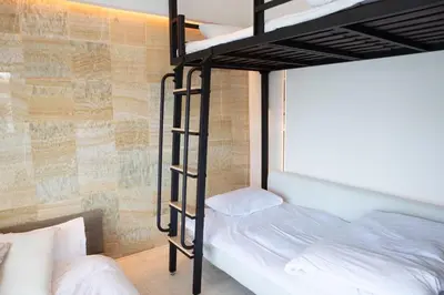 a bedroom with two bunk beds and a brick wall at \u516d\u672c\u6728\u9ebb\u5e03\u30b9\u30ab\u30a4\u30c6\u30e9\u30b9 in Tokyo
