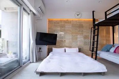 a bedroom with a bed and a flat screen tv at \u516d\u672c\u6728\u9ebb\u5e03\u30b9\u30ab\u30a4\u30c6\u30e9\u30b9 in Tokyo