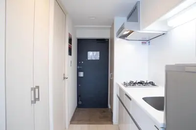 a kitchen with white cabinets and a blue door at \u516d\u672c\u6728\u9ebb\u5e03\u30b9\u30ab\u30a4\u30c6\u30e9\u30b9 in Tokyo