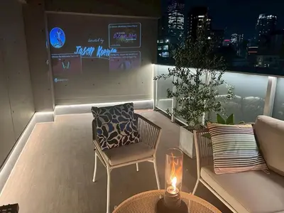 a balcony with a couch and a chair and a table at \u516d\u672c\u6728\u9ebb\u5e03\u30b9\u30ab\u30a4\u30c6\u30e9\u30b9 in Tokyo