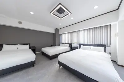 a hotel room with two beds with white sheets at Hanna Inn Shinbashi Onarimon in Tokyo