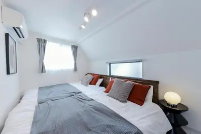 a bedroom with a large bed and a window at Seven's Inn Tateishi in Tokyo