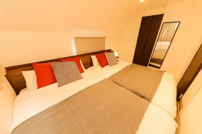 a bedroom with a large bed with red pillows at Seven's Inn Tateishi in Tokyo