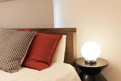 a bed with a pillow and a lamp on a table at Seven's Inn Tateishi in Tokyo