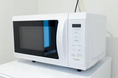 a white microwave oven sitting on a white table at Seven's Inn Tateishi in Tokyo