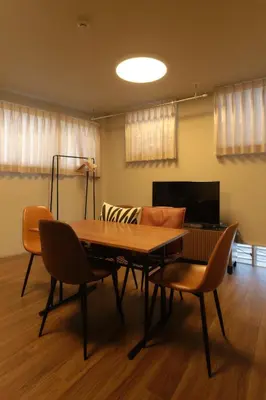 a dining room table with chairs and a couch at MATSUBARA Inn by Tranova in Tokyo