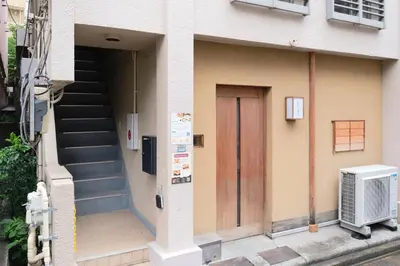 a building with a wooden door and stairs at MATSUBARA Inn by Tranova in Tokyo