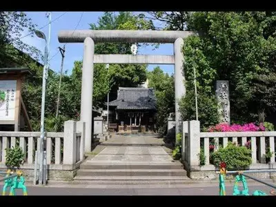 a gate leading to a temple with figurines in front at The Aki Shinjuku in Wada