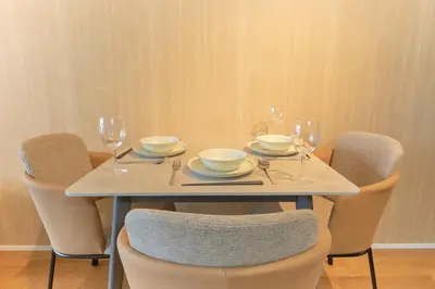 a table with chairs and a table with plates and wine glasses at U Place Shimokitazawa by Tranova in Tokyo