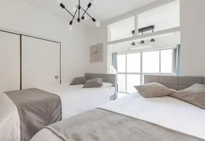 a white room with two beds and a window at sgc\u6771\u7acb\u77f32\u4e01\u76ee in Tokyo