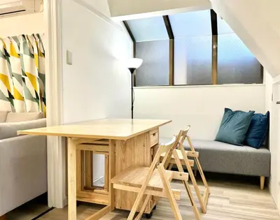 a table and chair in a small room with a couch at sgc\u6771\u7acb\u77f32\u4e01\u76ee in Tokyo