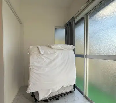 a bed in a room next to a window at sgc\u6771\u7acb\u77f32\u4e01\u76ee in Tokyo