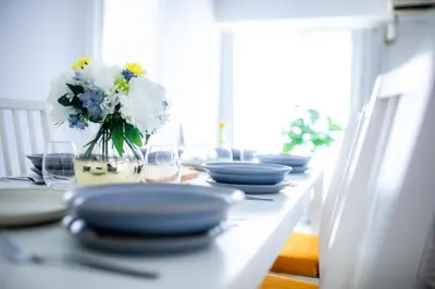 a table with blue and white plates and flowers on it at 4 min to Shinjuku - Up to 8pax - 3BR - Near Shibuya, Harajuku in Tokyo
