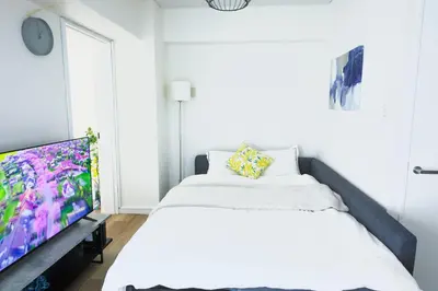 a bedroom with a bed and a flat screen tv at 4 min to Shinjuku - Up to 8pax - 3BR - Near Shibuya, Harajuku in Tokyo
