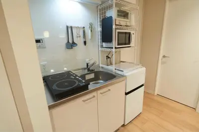 a small kitchen with a sink and a microwave at SGC\u8535\u524d2\u4e01\u76ee3f in Tokyo