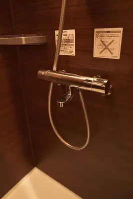 a bathroom with a metal shower handle on a wall at SGC\u8535\u524d2\u4e01\u76ee3f in Tokyo