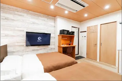 a bedroom with a tv on a brick wall at SAIE Sakura hotel in Tokyo