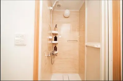 a bathroom with a shower with a glass door at SAIE Sakura hotel in Tokyo