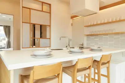 a kitchen with a large white island with chairs at Tokyo Sky Suite Hotel in Tokyo