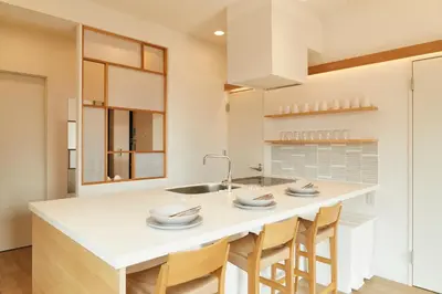 a kitchen with a large white island with chairs at Tokyo Sky Suite Hotel in Tokyo