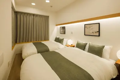 two beds in a room with a window at Tokyo Sky Suite Hotel in Tokyo