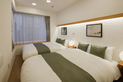 two beds in a room with a window at Tokyo Sky Suite Hotel in Tokyo